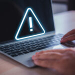 man-hand-on-laptop-with-exclamation-mark-on-virtual-screen-online-safety-warning