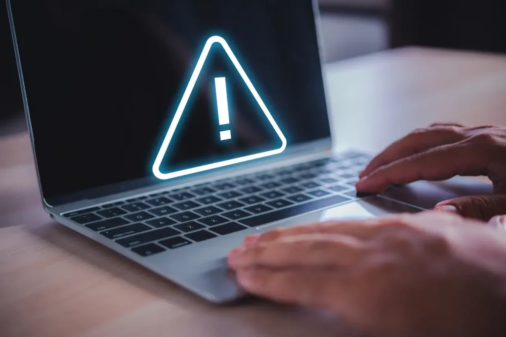 man-hand-on-laptop-with-exclamation-mark-on-virtual-screen-online-safety-warning